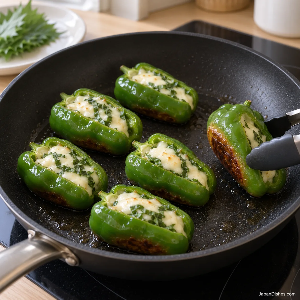Six stuffed peppers browning in a pan with their openings facing up