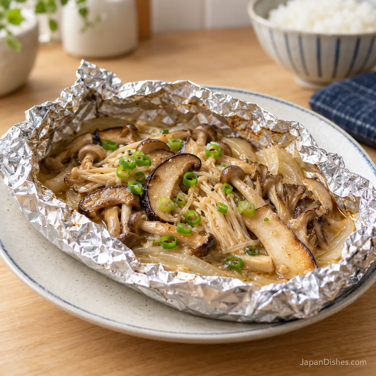 Miso butter mushrooms in an open foil packet on a Japanese ceramic plate