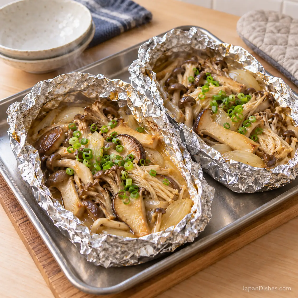 Cooked miso butter mushrooms in two opened foil packets after baking