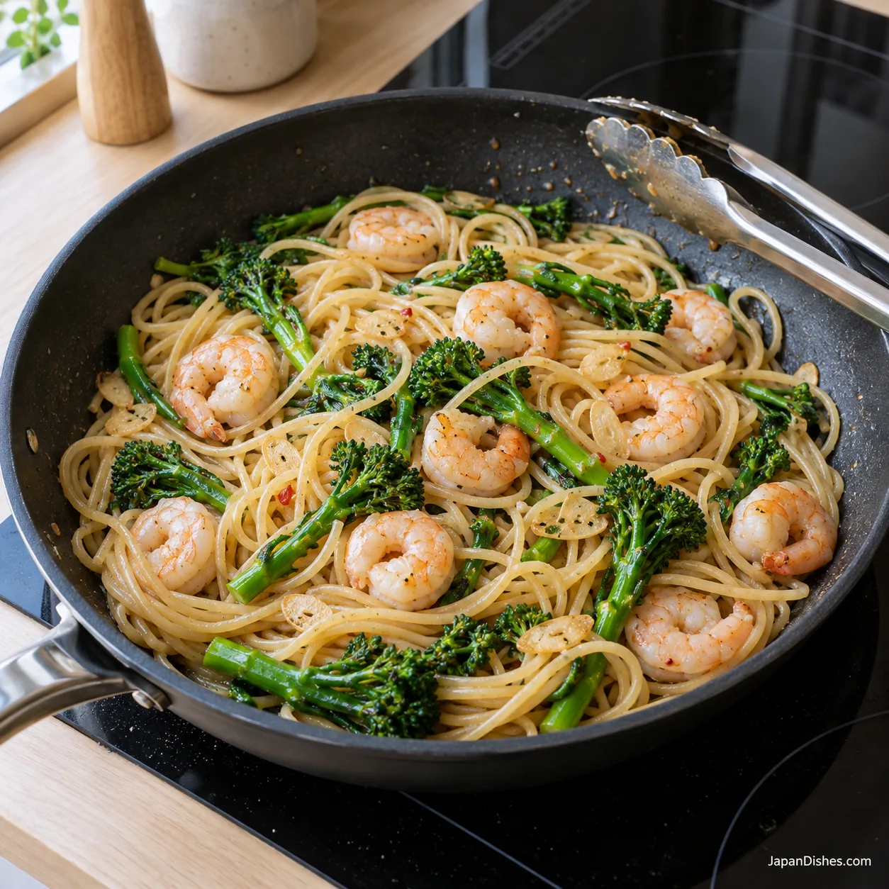 Cooked shrimp and broccolini tossed with spaghetti, garlic and light soy-butter sauce in a pan