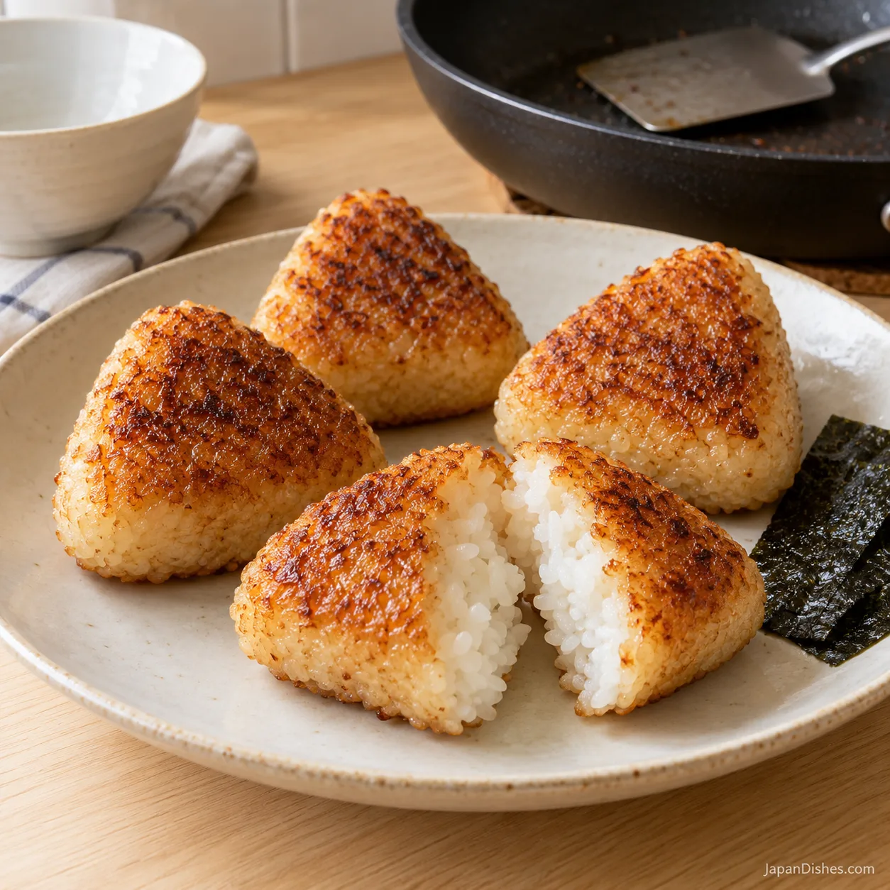 Yaki onigiri broken open to reveal fluffy plain rice beneath the crust