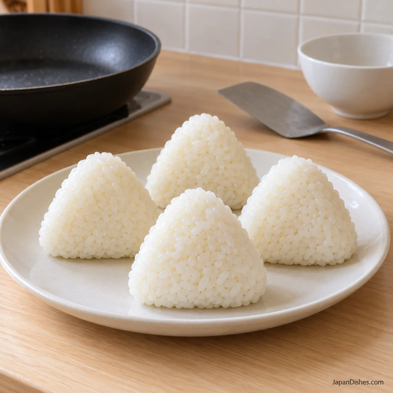 Four unglazed triangular rice balls with compact sealed edges