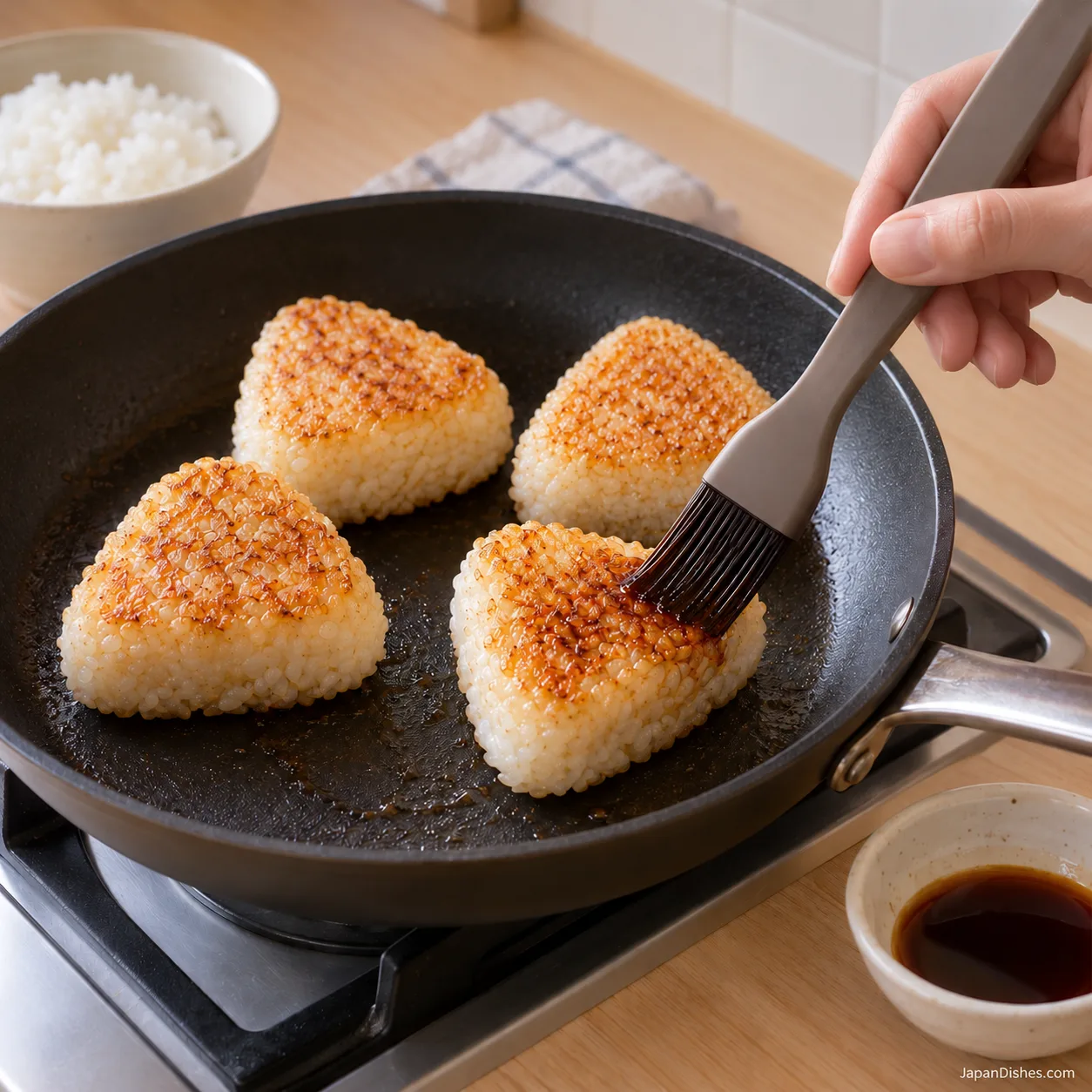 Thin soy glaze brushed onto one of four golden rice balls